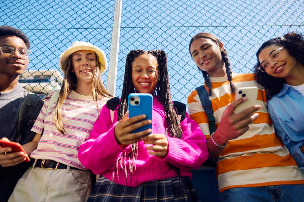 Diverse group of friends checking phones together